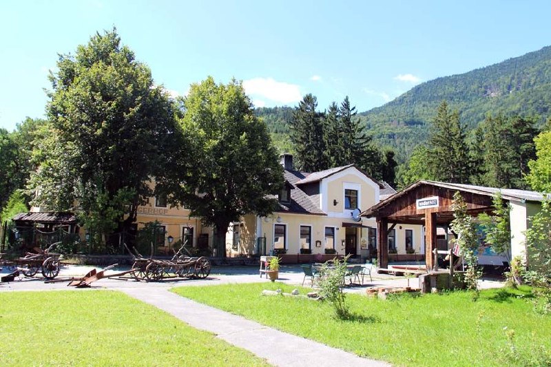 Commons Hub buildings and green courtyard beneath the Austrian Alps